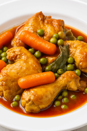 poulet mijoté aux carottes et petits pois, nappé d’une sauce rouge