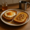 Deux tartines dorées posées sur une assiette dans une cuisine chaleureuse : l’une avec un œuf nuage légèrement caramélisé à la cannelle, l’autre nappée de miel et parsemée d’éclats de noisettes.